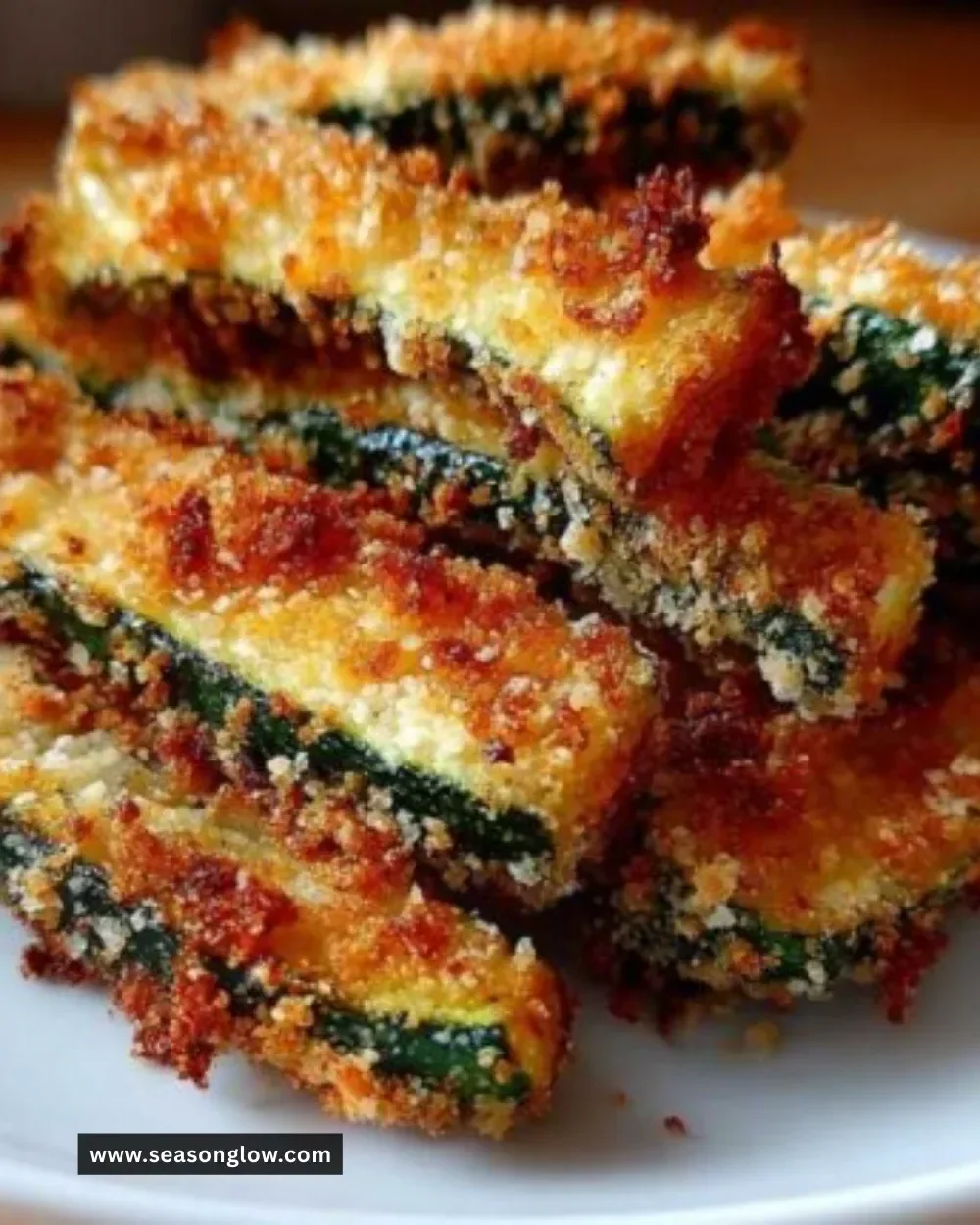 Crispy baked zucchini fries topped with parmesan cheese on a plate
