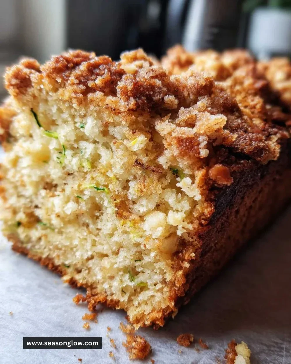 Loaf of bakery style cinnamon streusel zucchini bread with a golden crumb topping