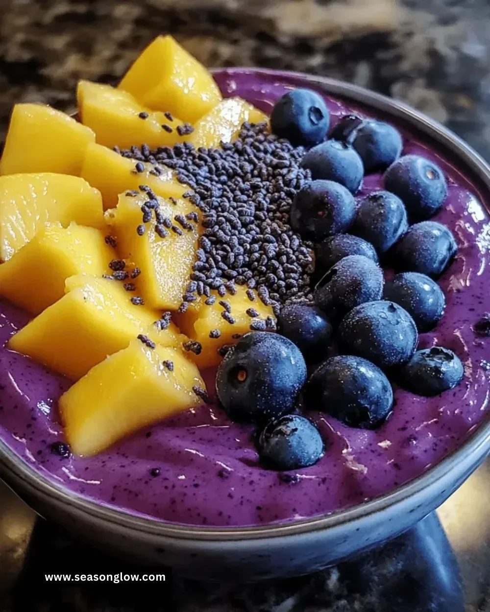 Delicious Mango Blueberry Smoothie Bowl topped with fresh fruits and granola