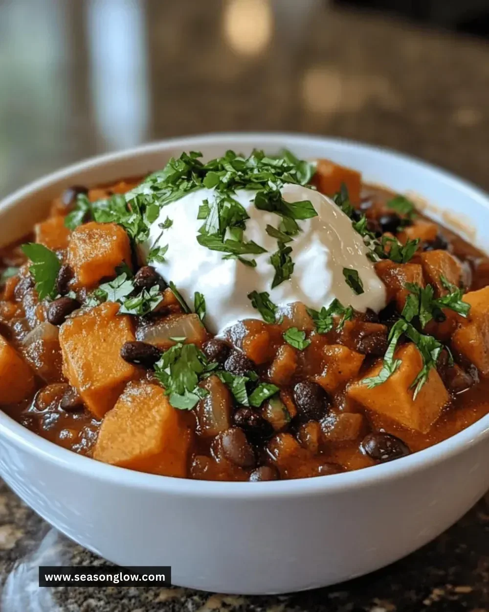 Bowl of sweet potato black bean chili topped with fresh herbs
