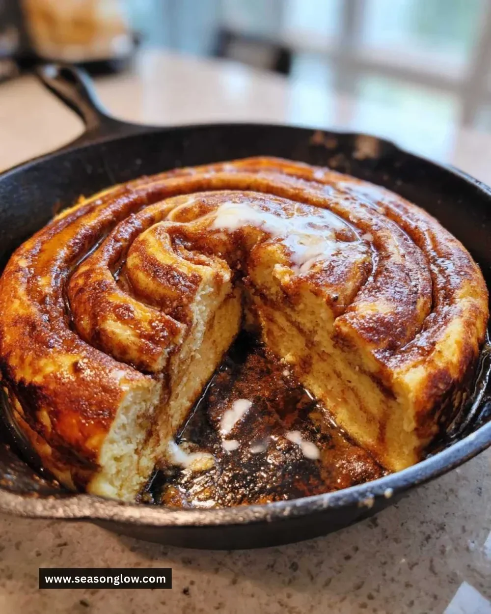 Delicious cinnamon roll pancake skillet topped with cream cheese icing.