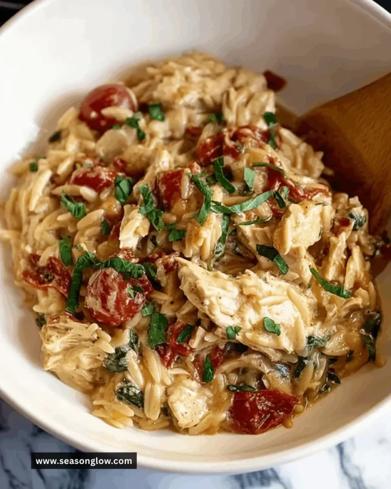 Bowl of Classic Crockpot Tuscan Chicken Orzo with vegetables and herbs