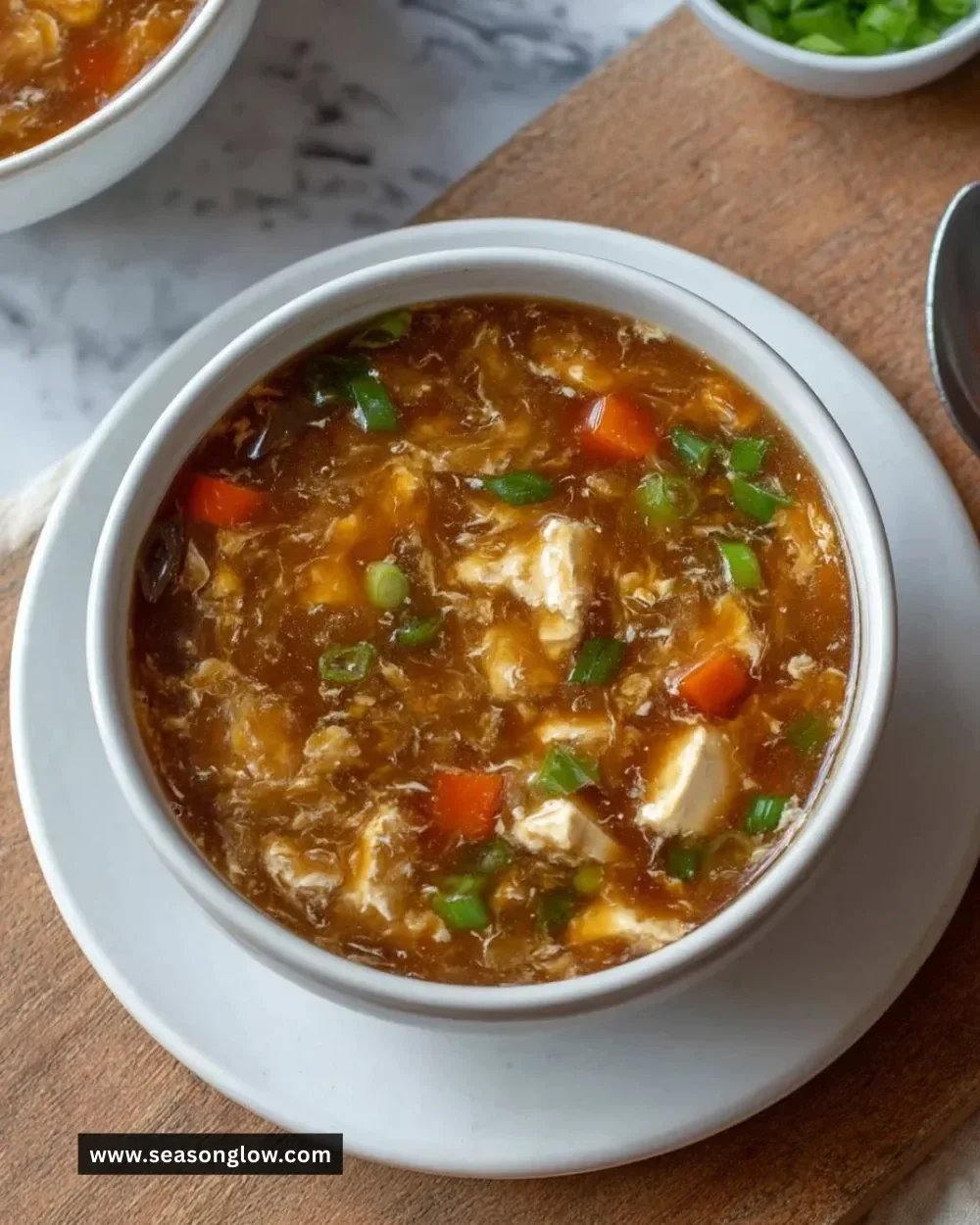 Bowl of classic hot and sour soup garnished with herbs and spices