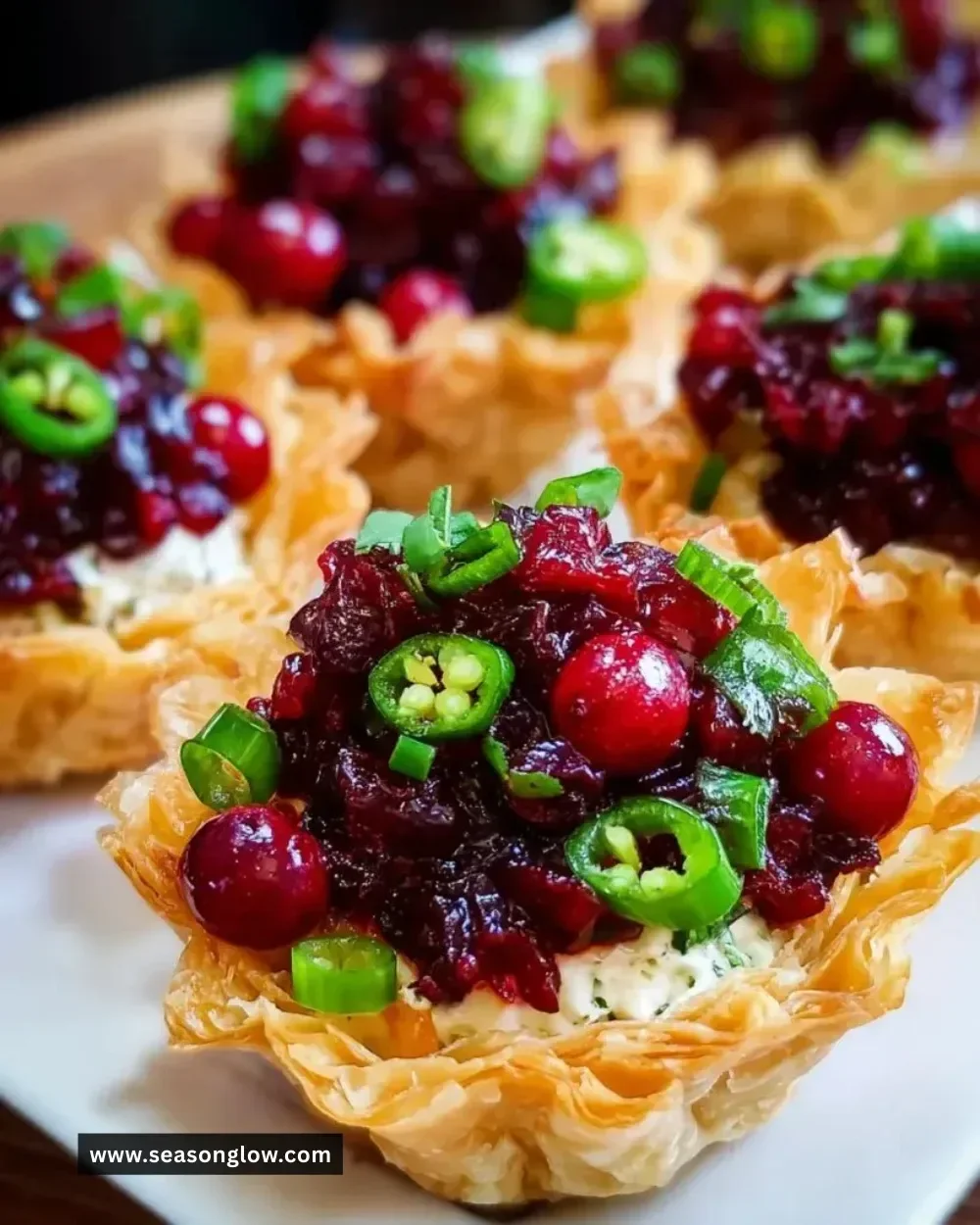 Cranberry Jalapeño Dip Tarts served on a wooden table