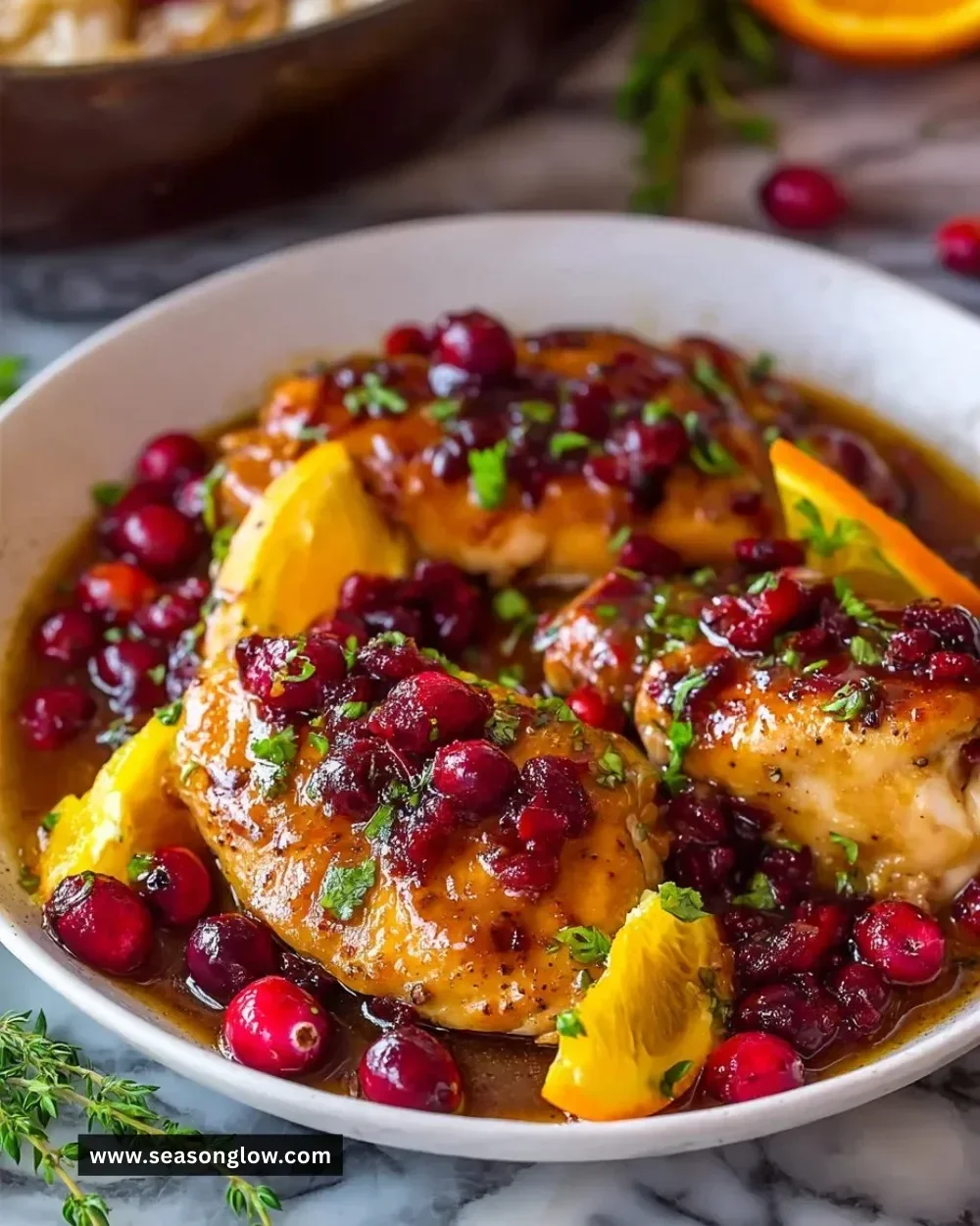 Cranberry Orange Chicken dish garnished with fresh herbs and fruit slices