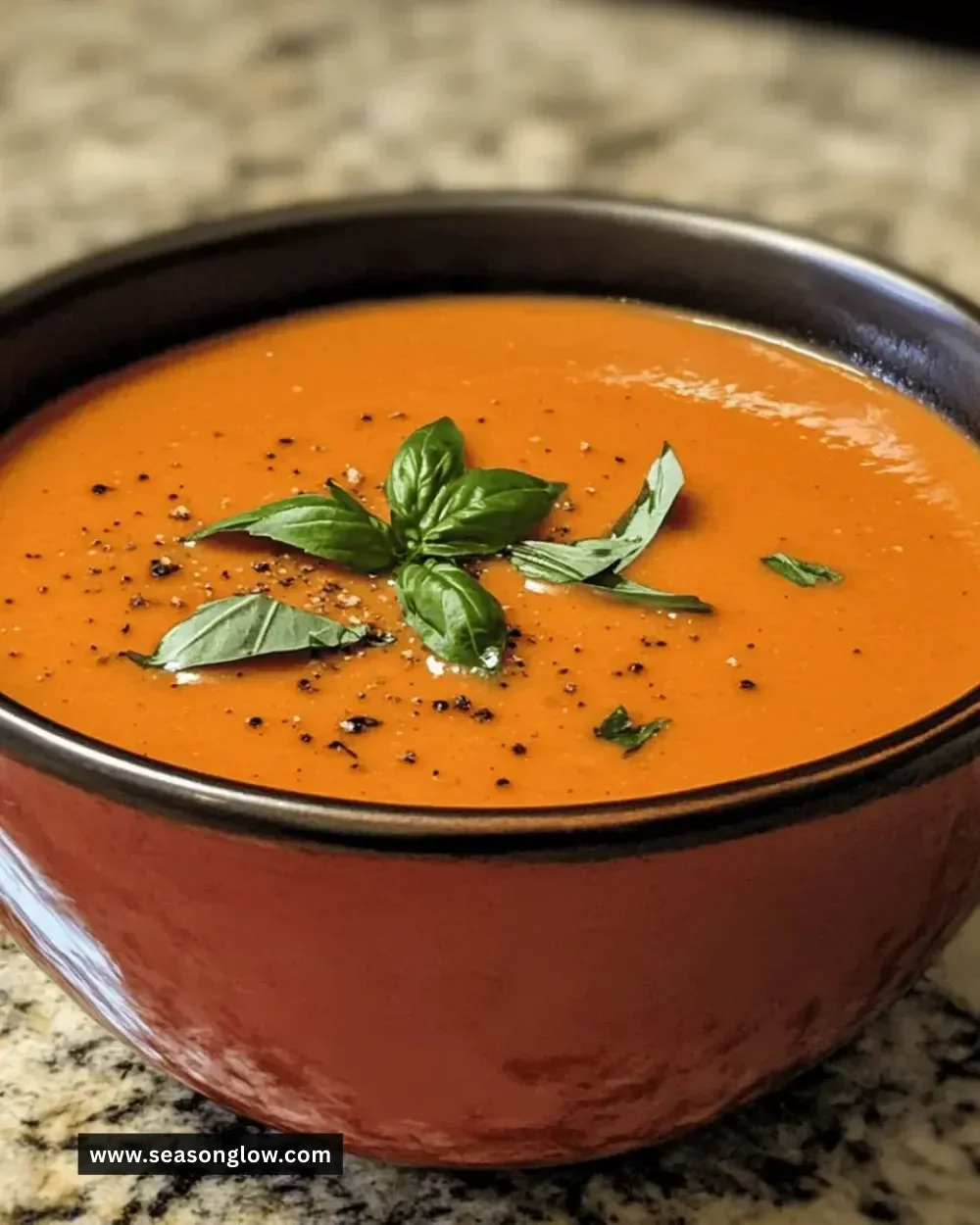 Bowl of creamy tomato basil soup garnished with fresh basil leaves