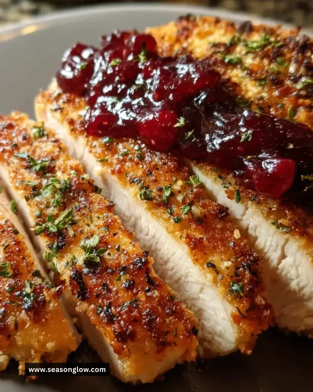 Crusted turkey fillets served with vibrant cranberry sauce on a plate.