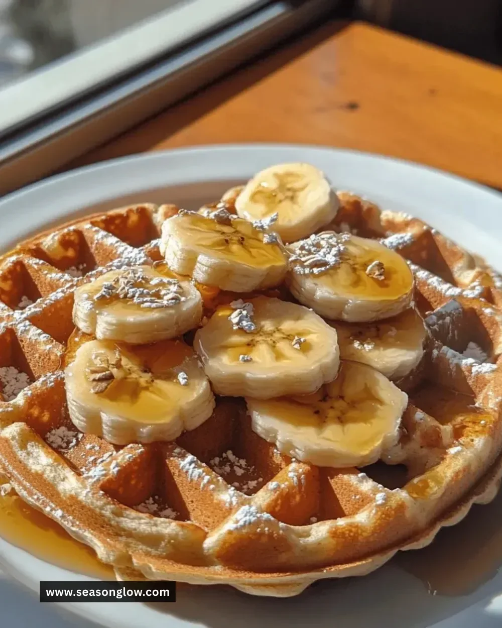 Easy gluten-free banana oat waffles served on a plate with syrup and fresh fruit.