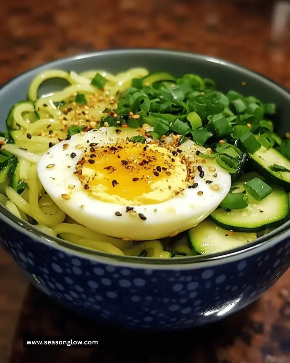 Gluten-free zucchini noodle egg bowl topped with fresh herbs and spices