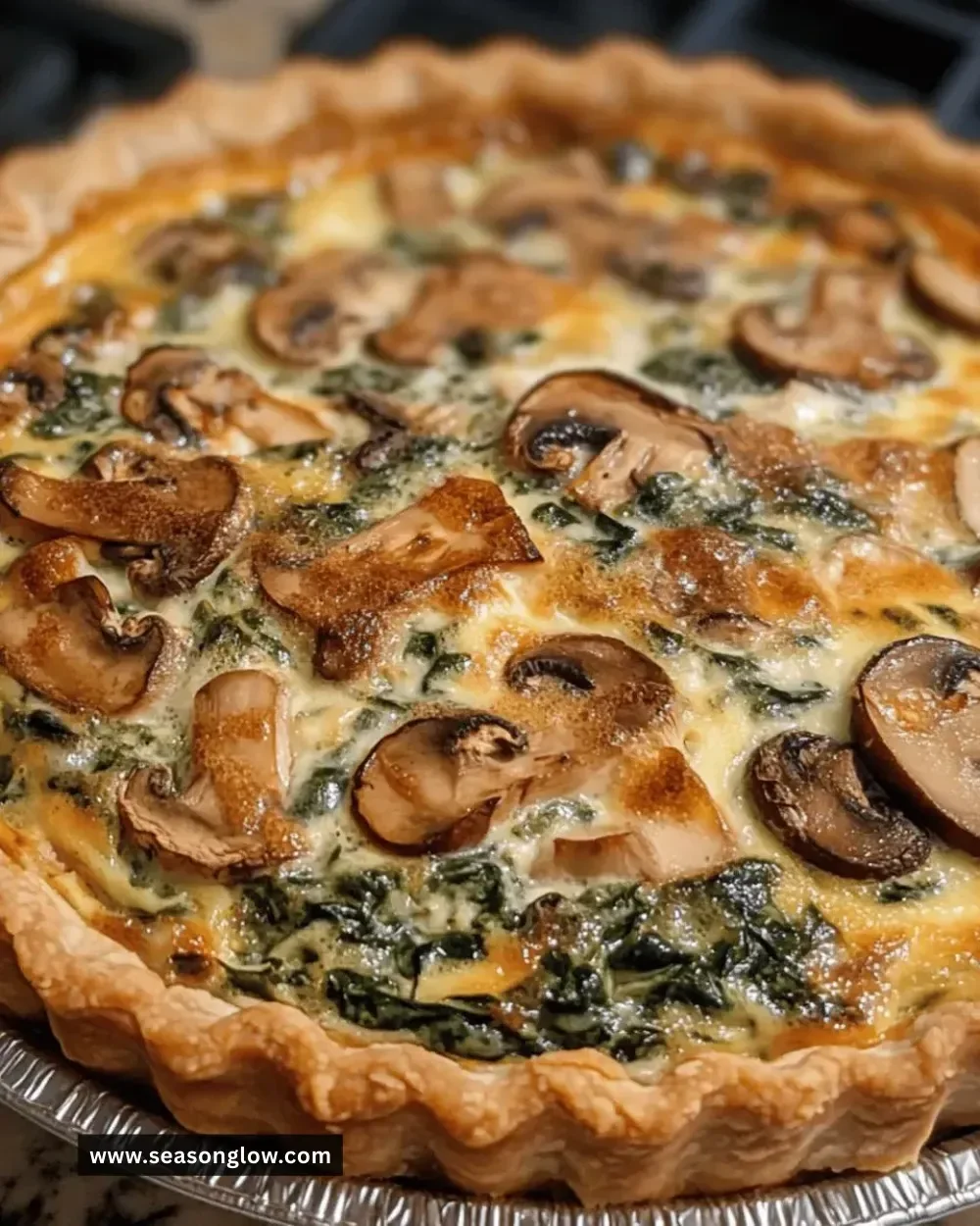 Easy mushroom spinach quiche served on a plate with greens