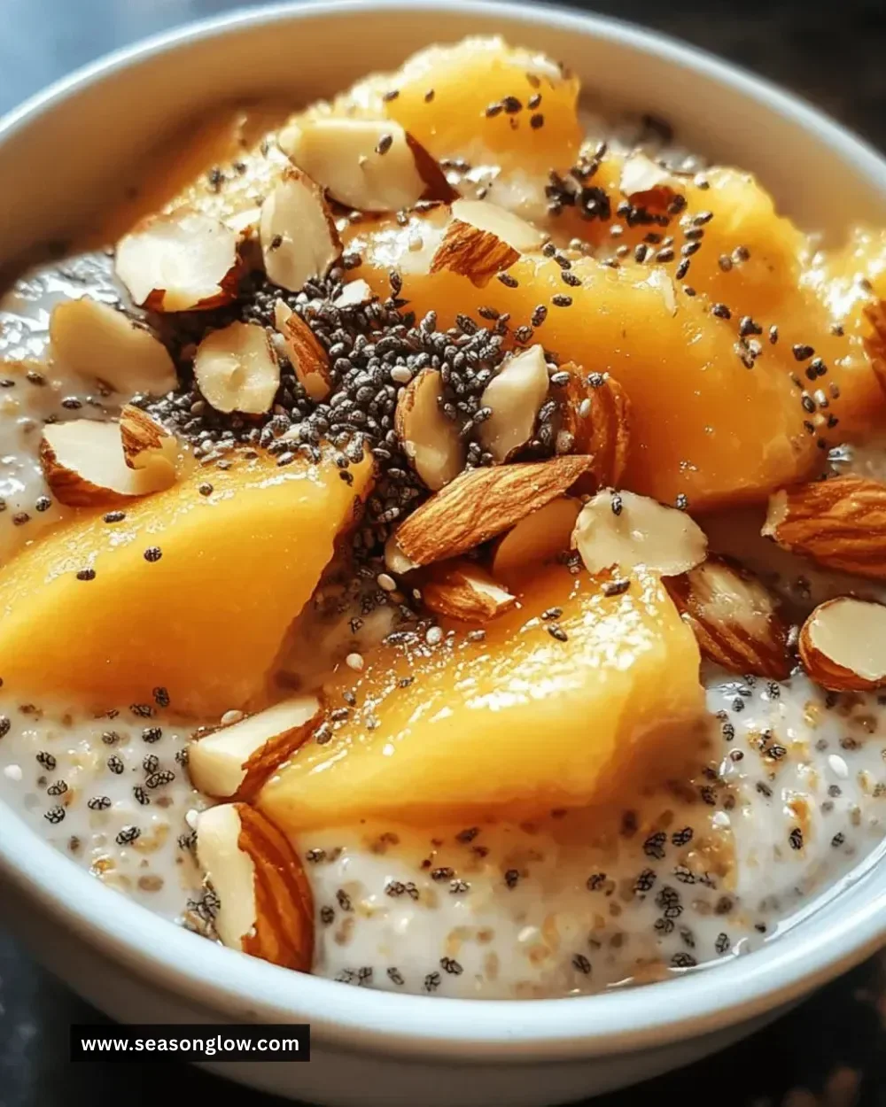 Bowl of easy peach almond chia oats topped with fresh peaches and almonds