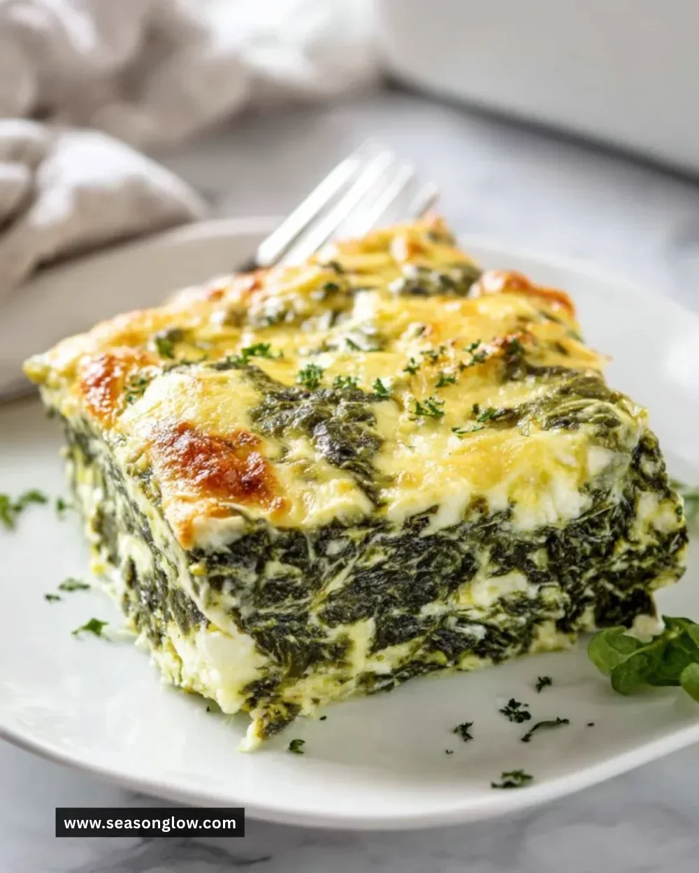 Delicious easy spinach casserole served in a baking dish with cheese on top