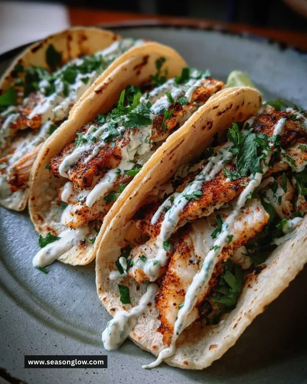 Plate of delicious fish tacos topped with fresh cilantro and lime