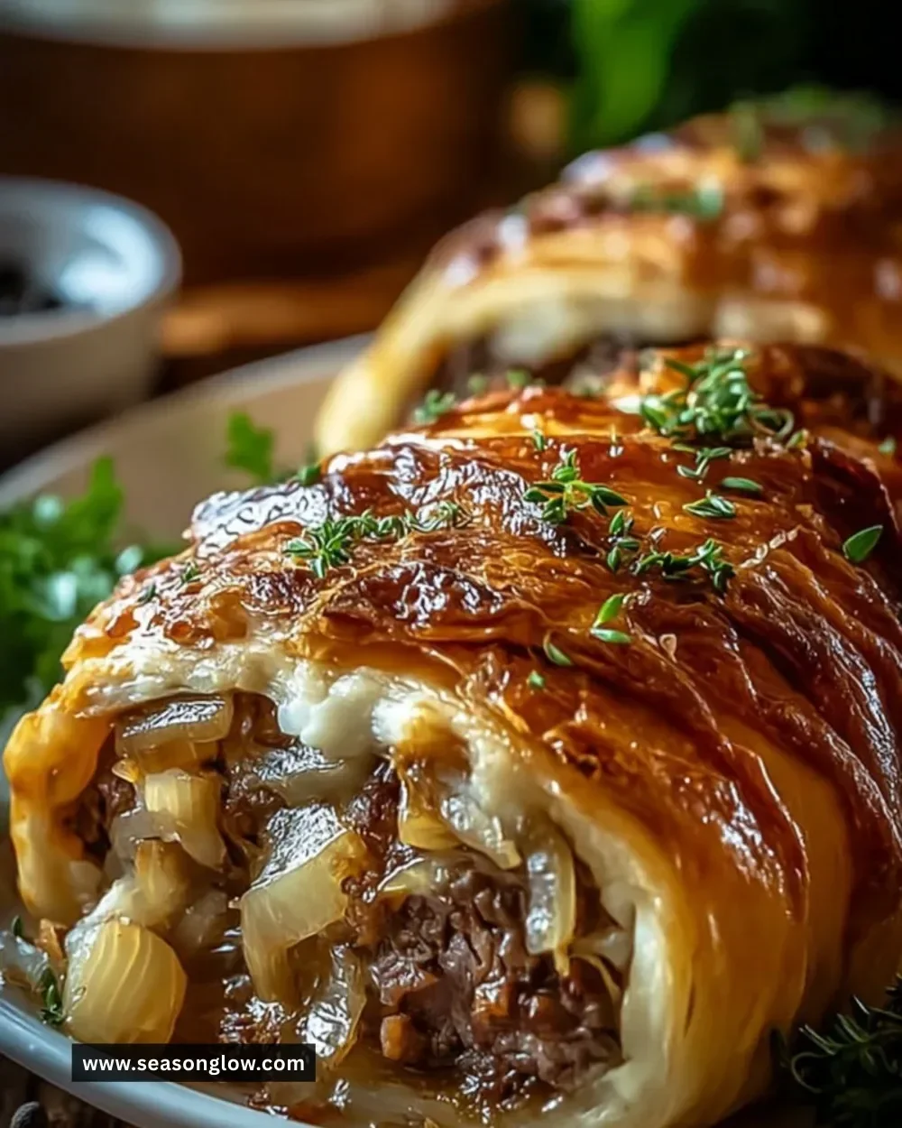 Delicious French Onion Beef Roll garnished with herbs and melted cheese