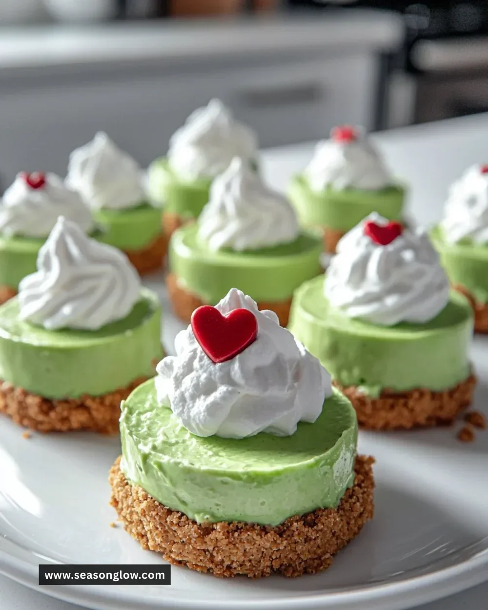 Grinch mini cheesecakes decorated with holiday flair and vibrant colors.