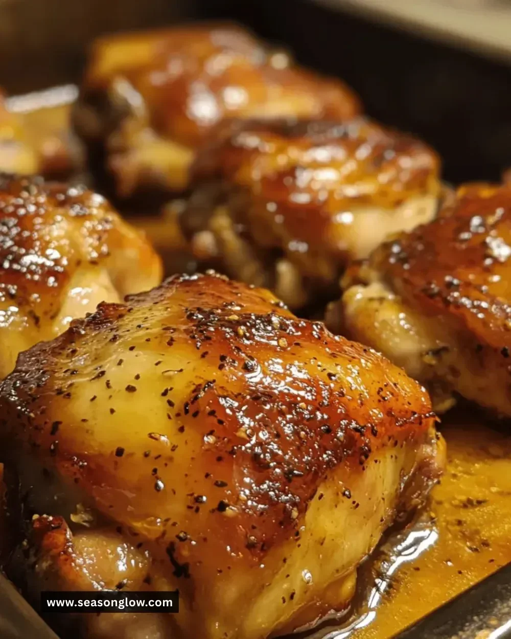 Juicy maple-mustard glazed chicken thighs on a plate garnished with herbs.