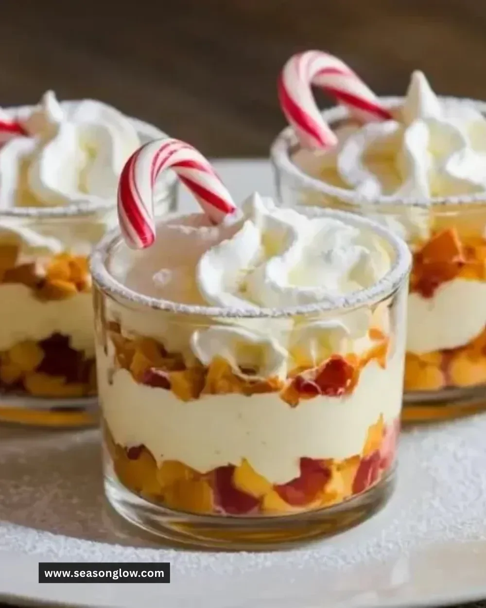 Mini Christmas trifles with layers of festive cream and fruits in glasses