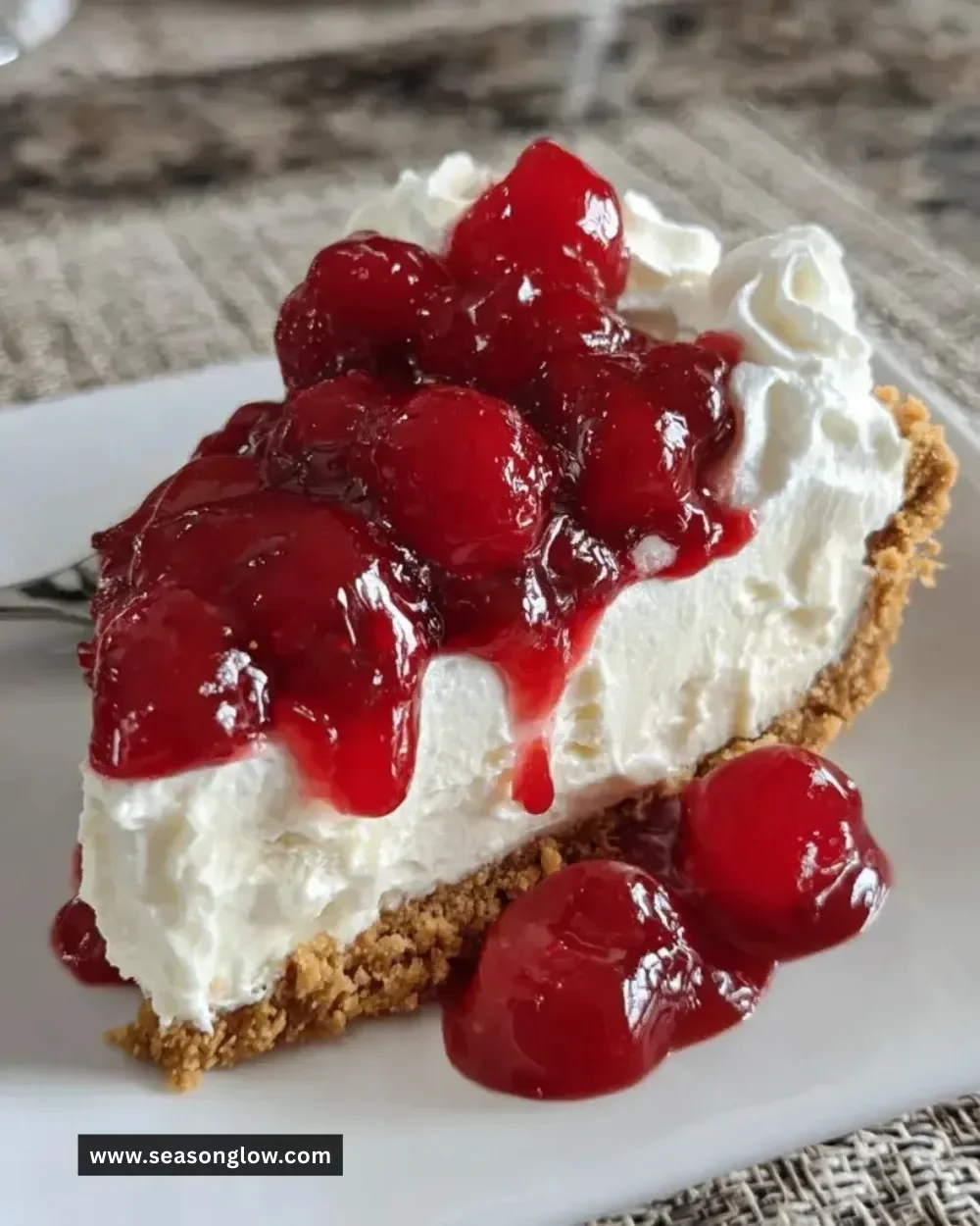 A delicious no-bake cherry cheesecake topped with vibrant red cherries.