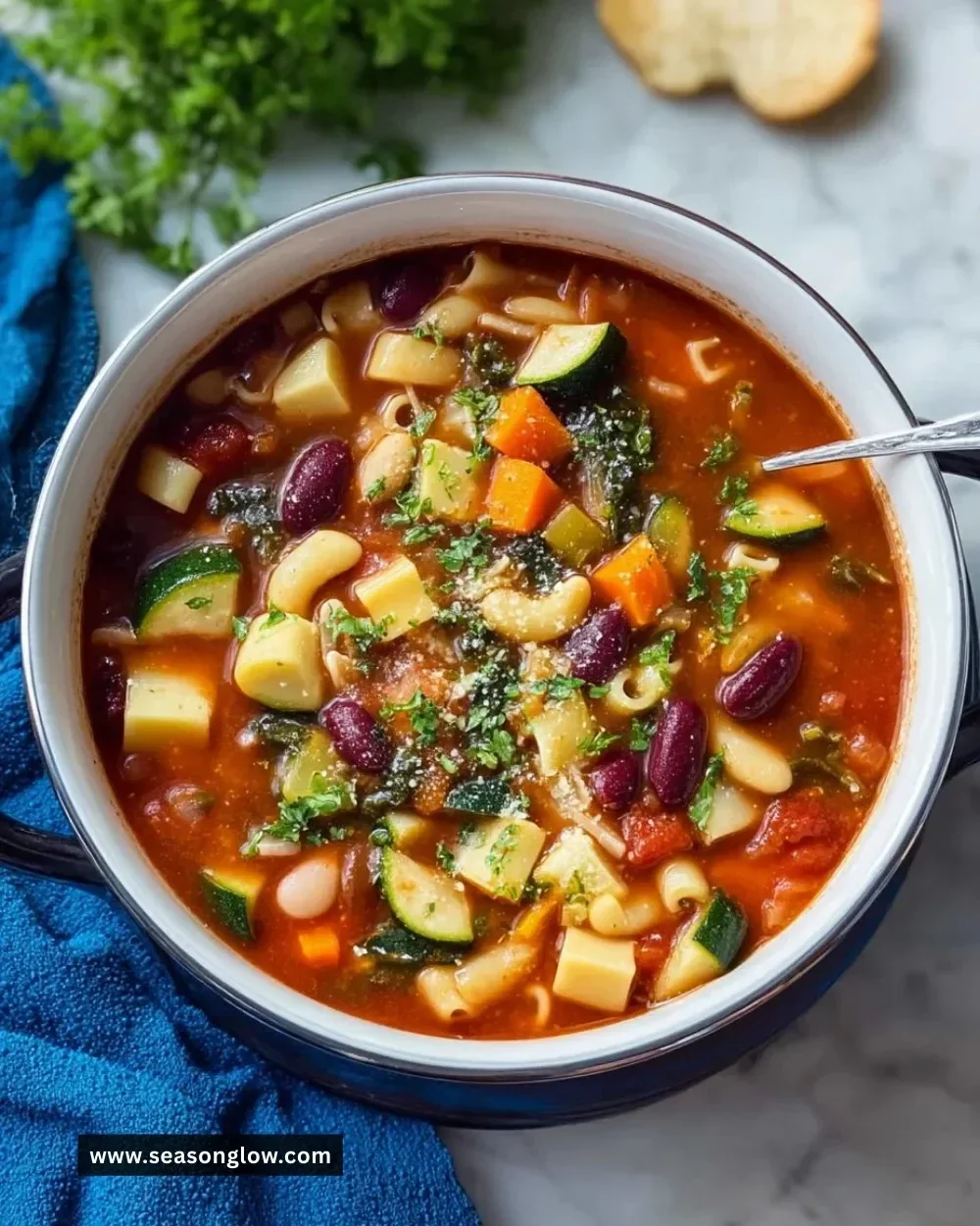 Bowl of Olive Garden minestrone soup with vegetables and beans on a wooden table.