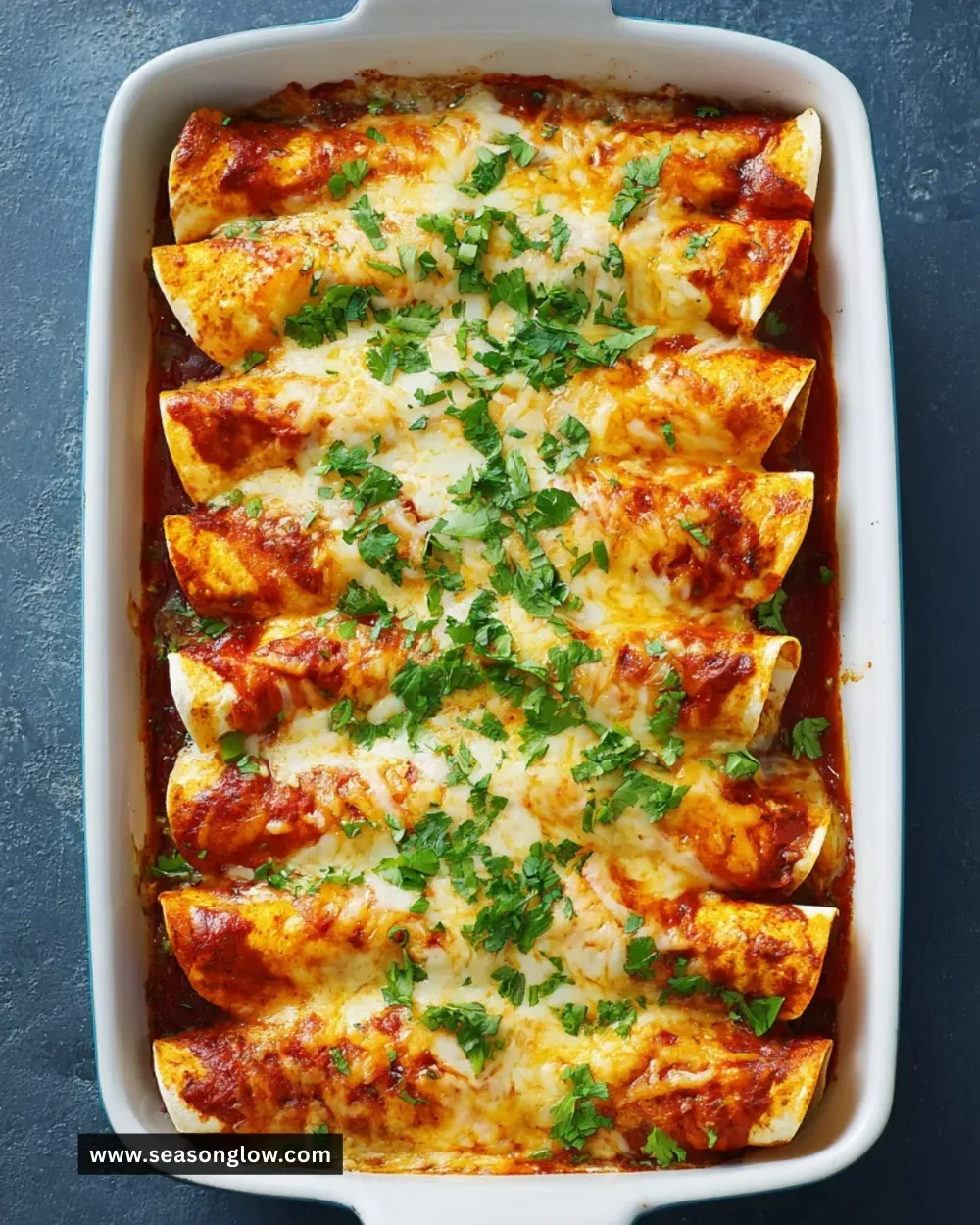 Over-the-Border Shrimp Enchiladas topped with sauce and garnished with cilantro