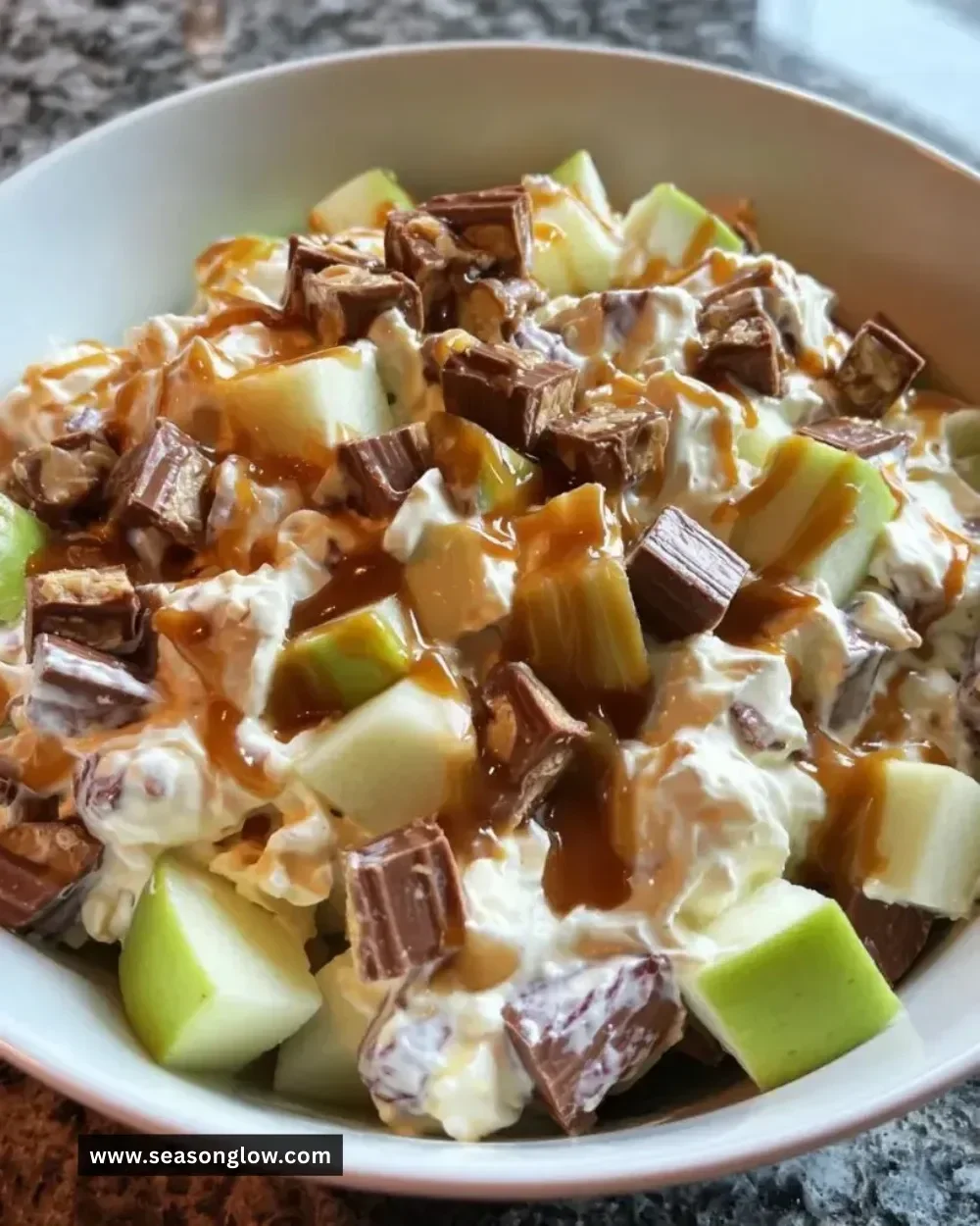 Delicious Snickers caramel apple salad with chunks of apples and caramel drizzles