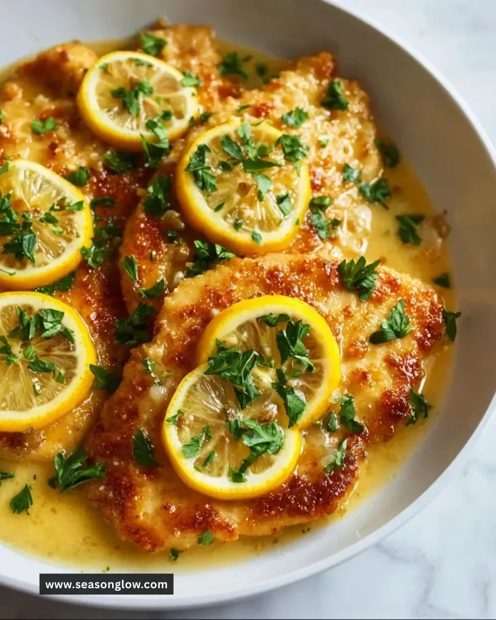 Delicious Chicken Francese served with lemon and parsley on a plate.