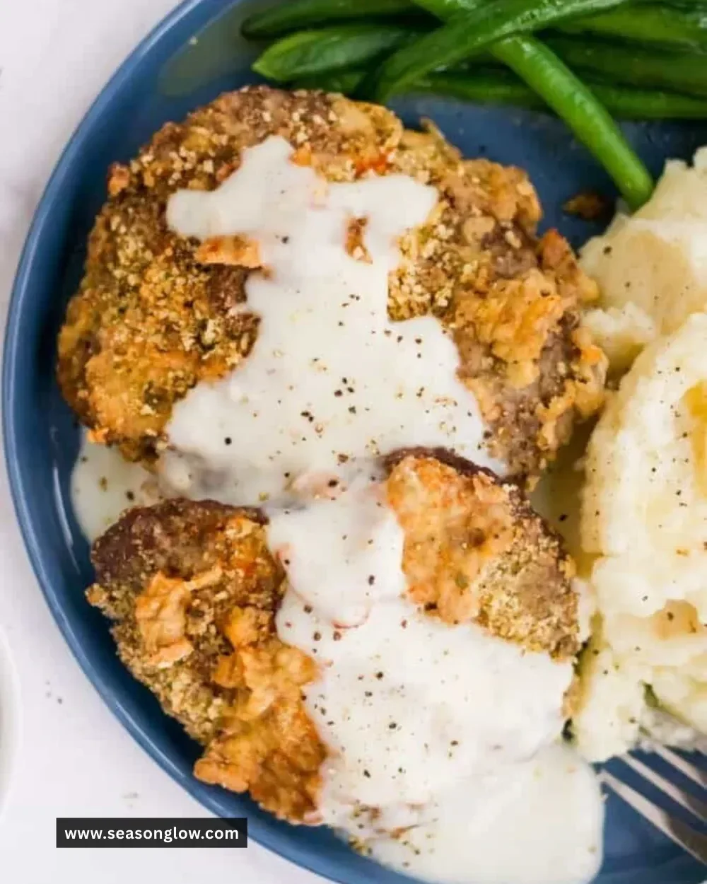 Crispy air fryer chicken fried steak on a plate with gravy and sides
