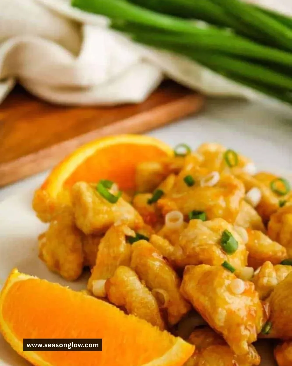 Plate of delicious Air Fryer Orange Chicken garnished with sesame seeds and green onions