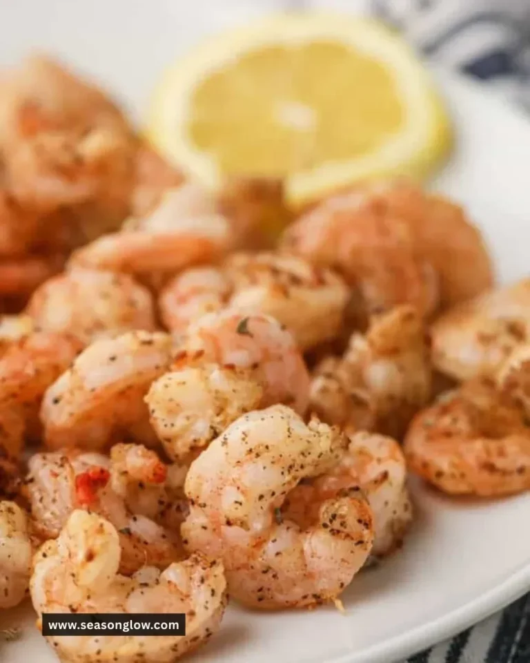Plate of crispy air fryer shrimp garnished with lemon and herbs