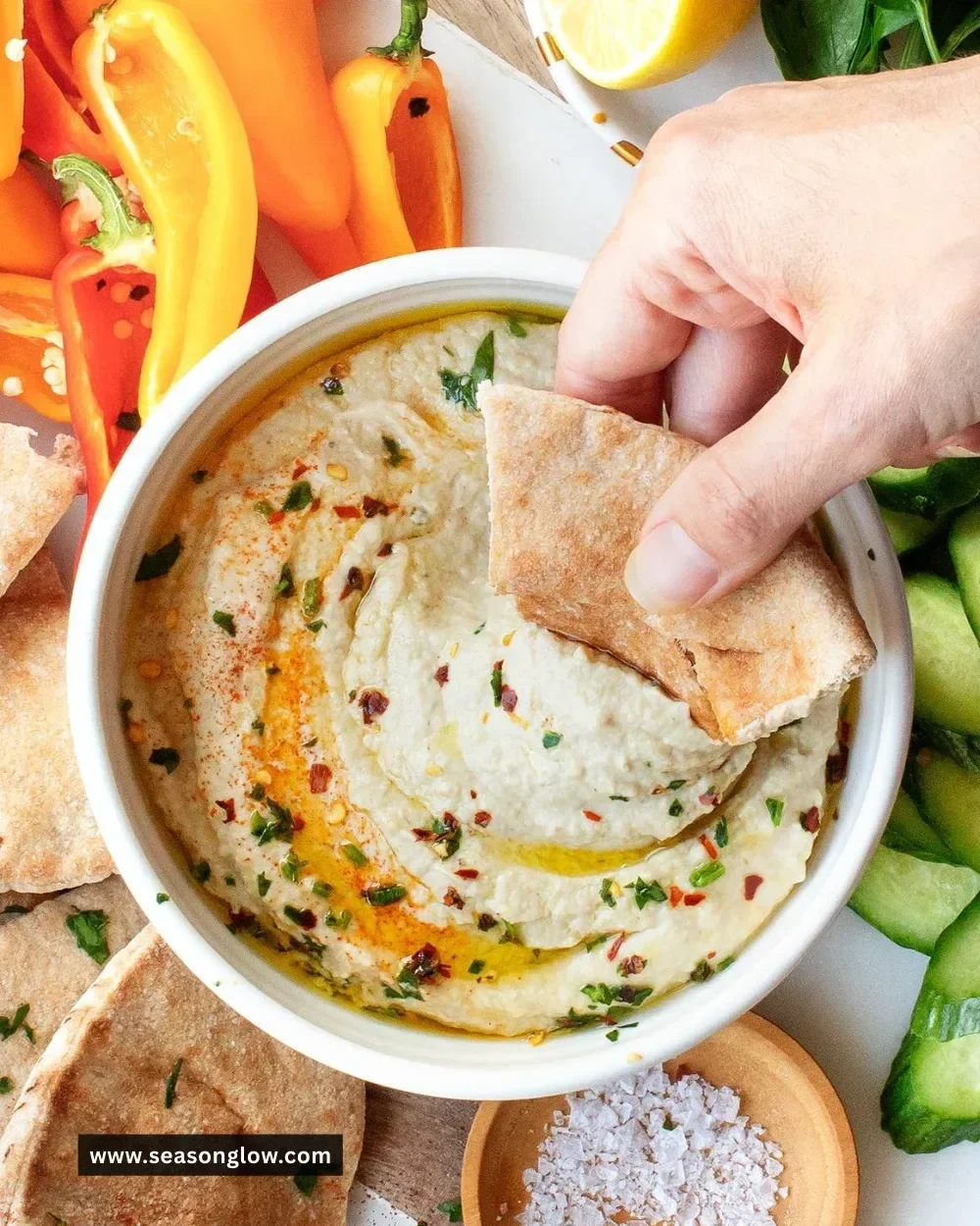 Baba Ganoush served in a bowl with pita bread and garnished with olive oil and herbs.