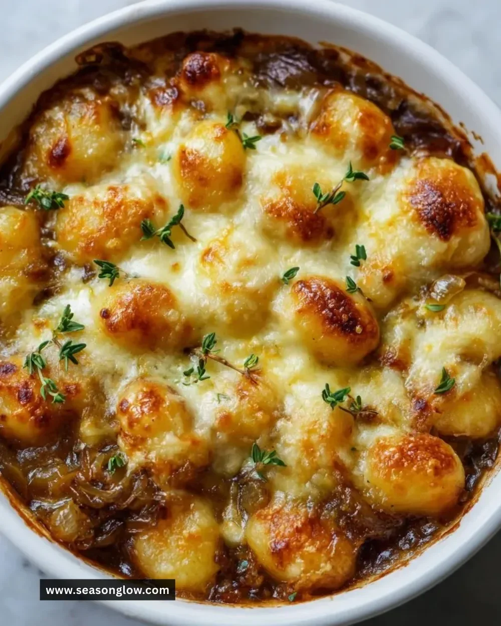 Delicious baked French onion gnocchi topped with melted cheese and herbs