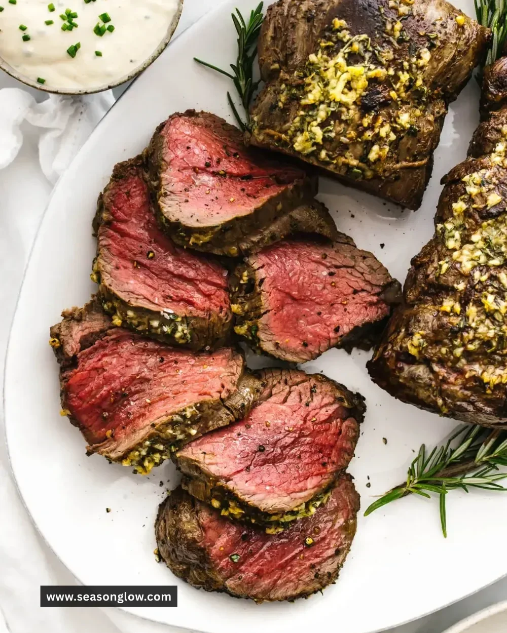 Perfectly cooked beef tenderloin roast served with herbs and vegetables