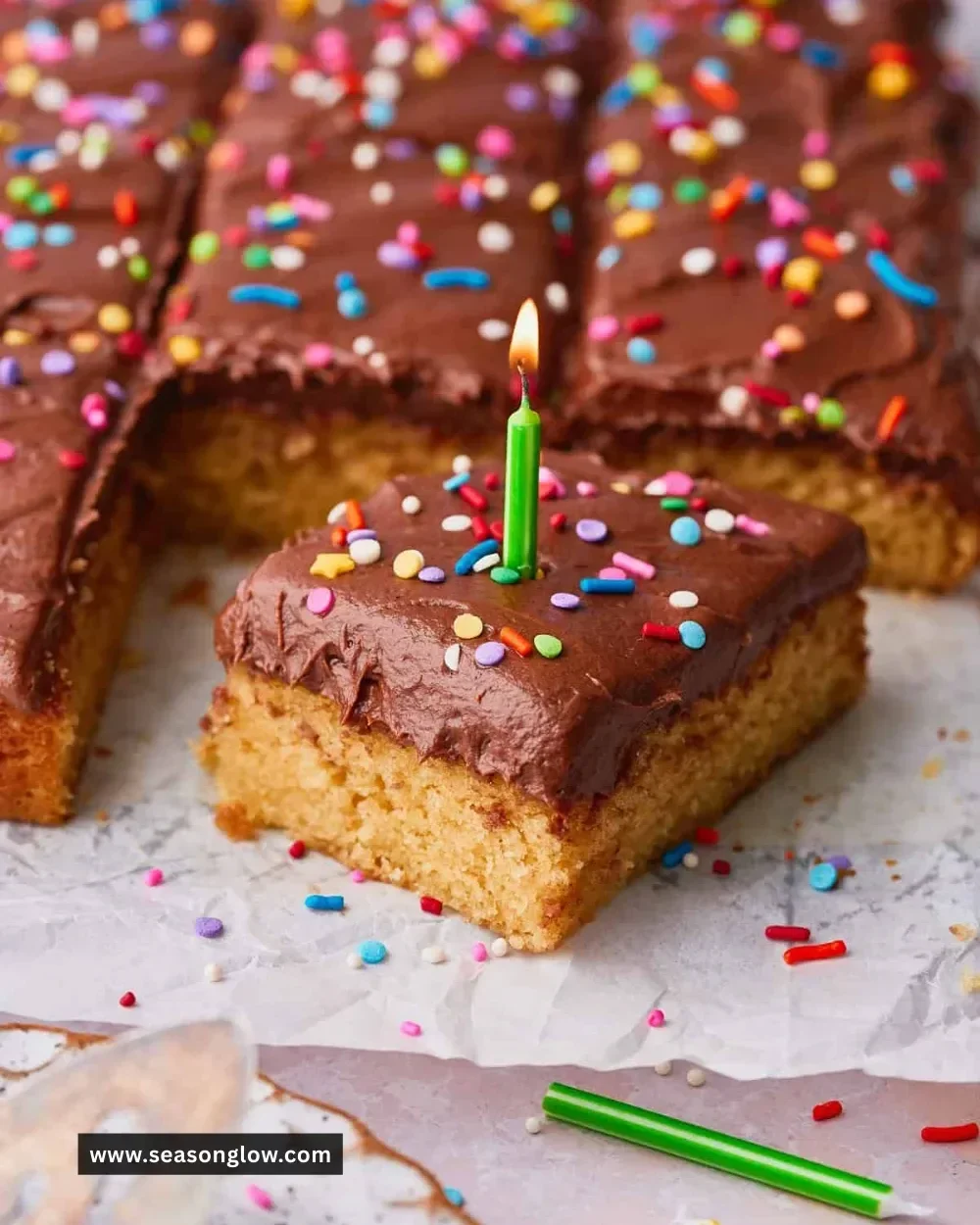 Colorful birthday sheet cake decorated with frosting and candles.