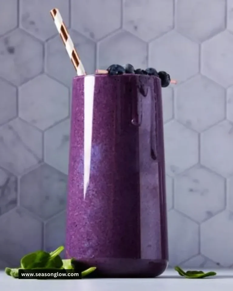 Fresh blueberry smoothie in a glass with berries and mint garnish
