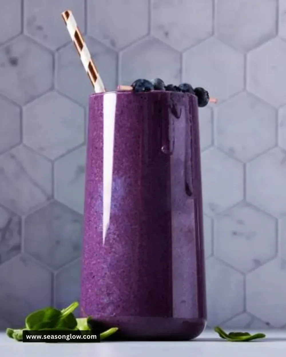 Fresh blueberry smoothie in a glass with berries and mint garnish