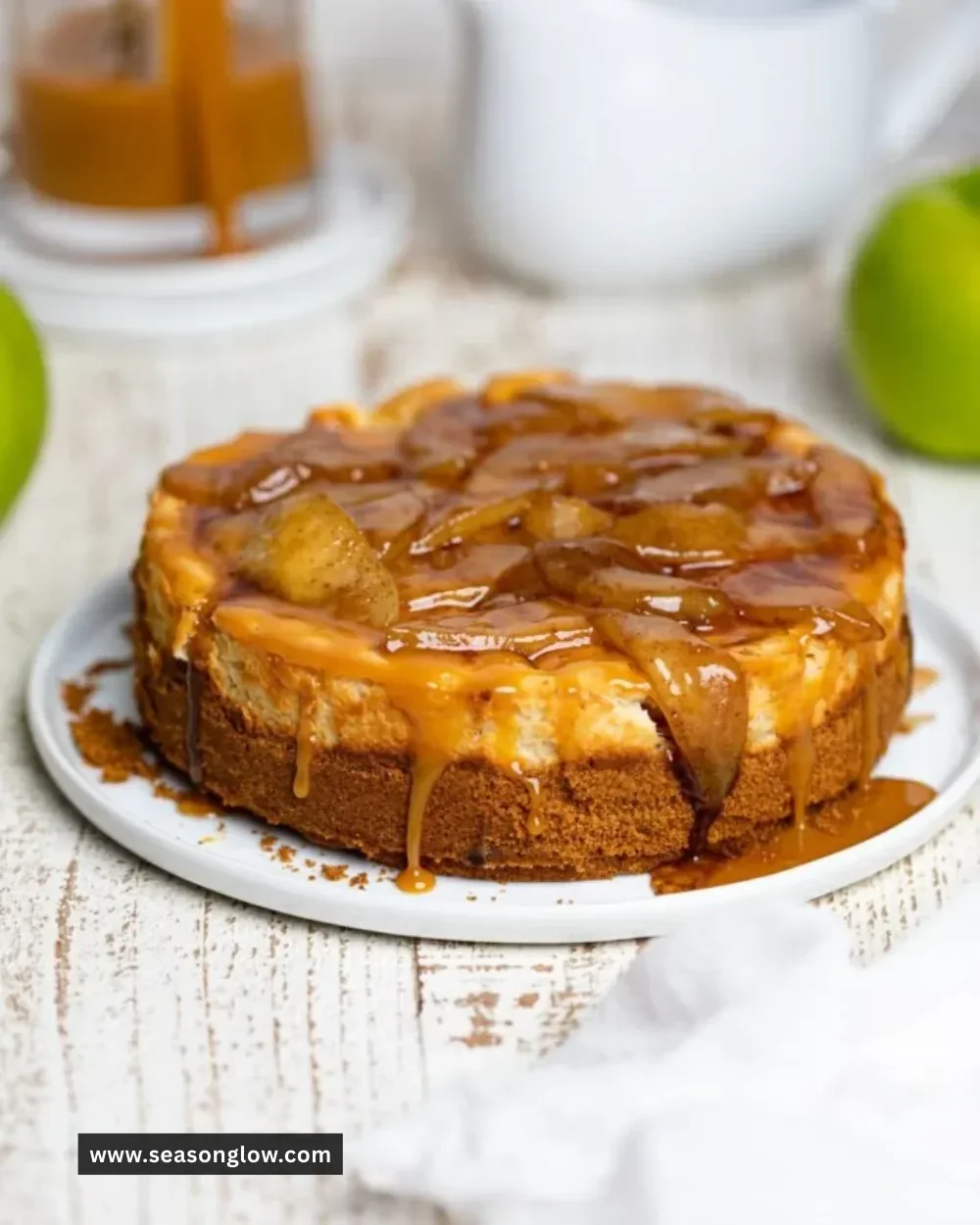Delicious caramel apple cheesecake topped with caramel drizzle and apple slices