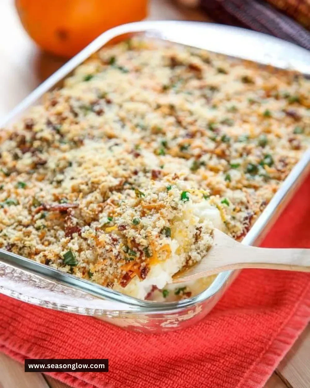 Cheesy mashed potato casserole topped with crispy bacon, served in a baking dish