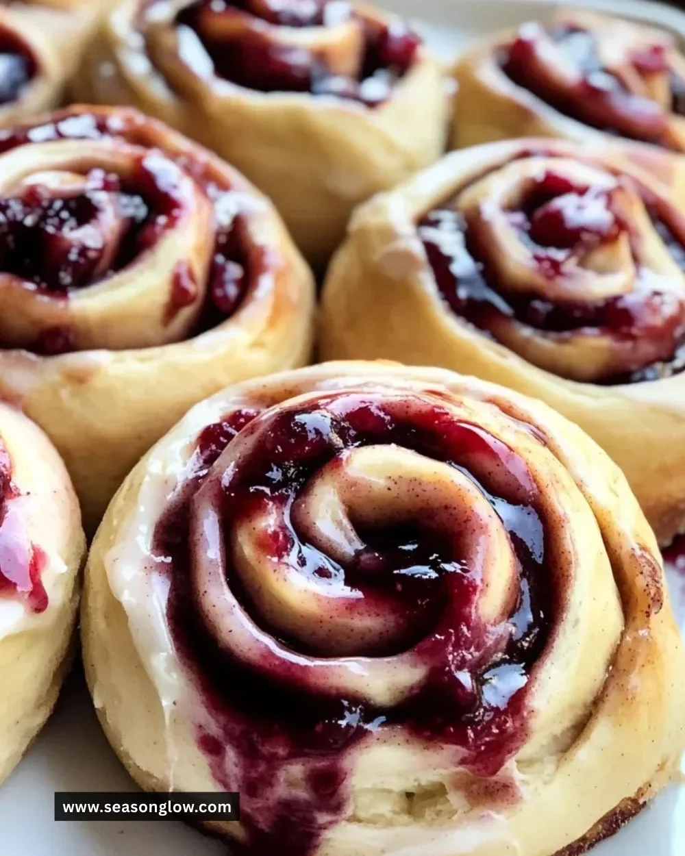 Fresh cherry cinnamon rolls with homemade filling on a wooden table.