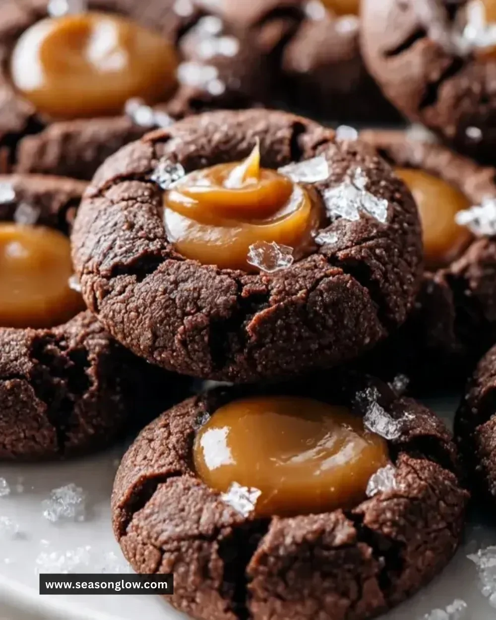 Chocolate Caramel Thumbprint Cookies on a baking tray, drizzled with caramel.