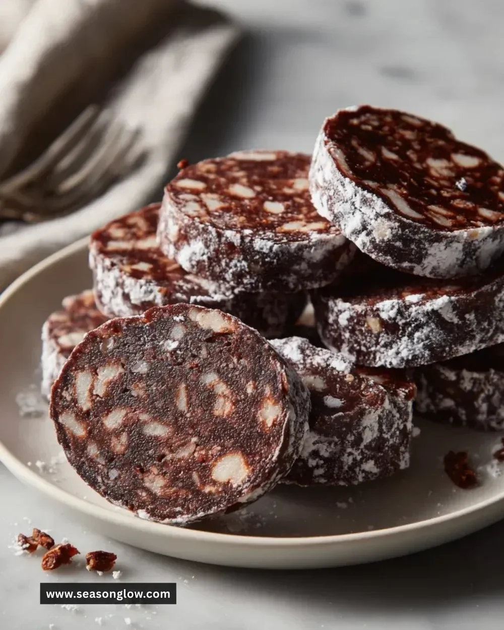 Classic chocolate salami dessert with chocolate, nuts, and a dusting of cocoa powder