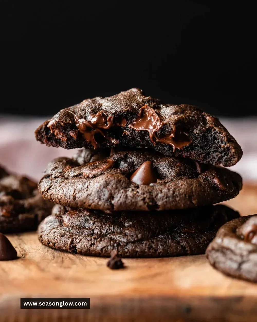 Freshly baked double chocolate chip cookies stacked on a plate.