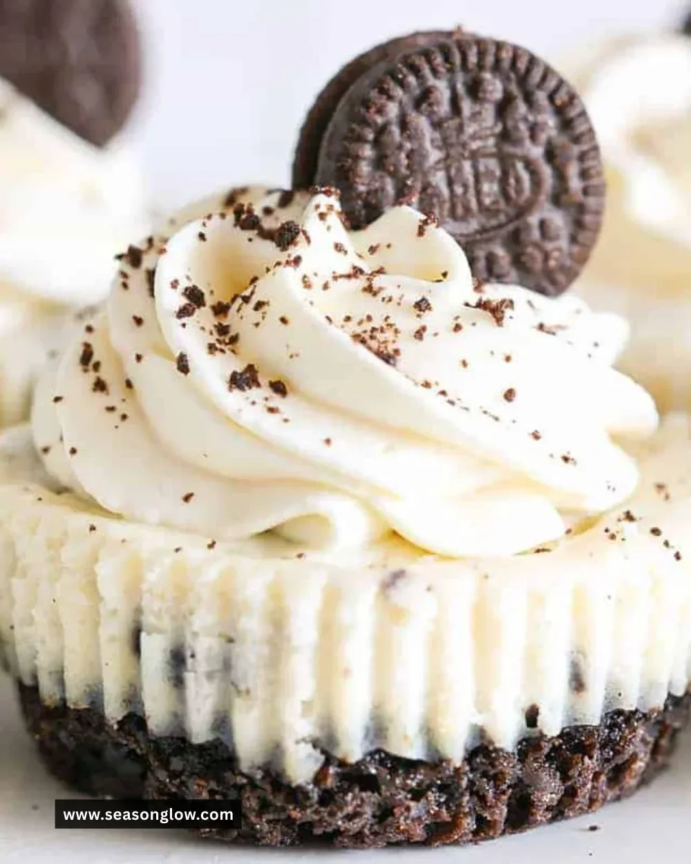 Mini Oreo cheesecake bites topped with crushed Oreos on a white plate