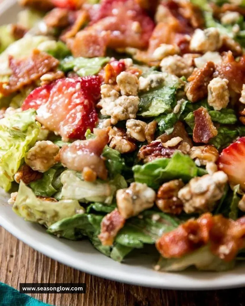 Delicious strawberry bacon salad topped with fresh greens and a creamy dressing.