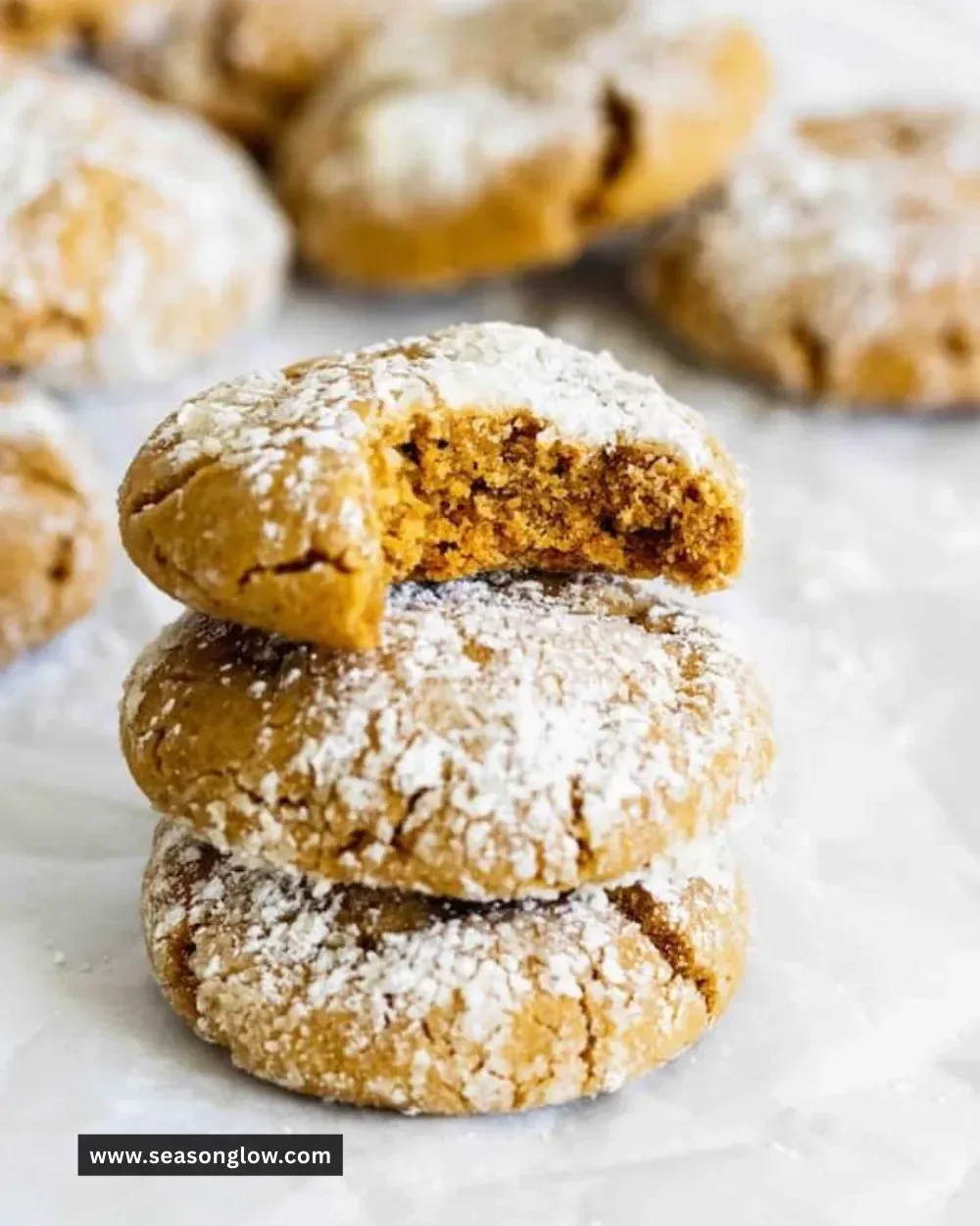 Gingerbread crinkle cookies dusted with powdered sugar on a festive table