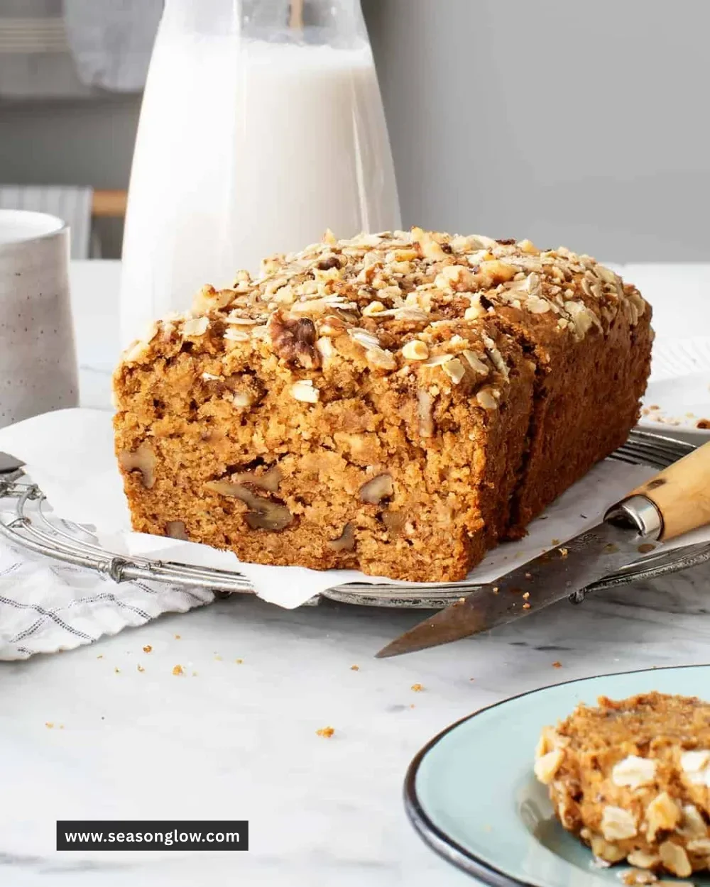 Healthy banana bread loaf with nuts and ingredients on a wooden table