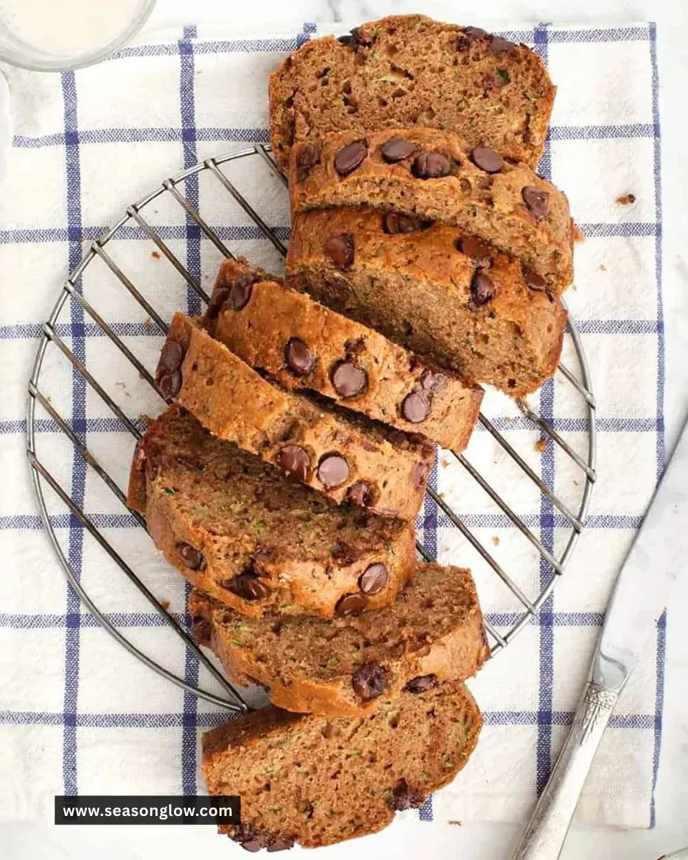 Sliced healthy zucchini bread on a plate with fresh zucchini