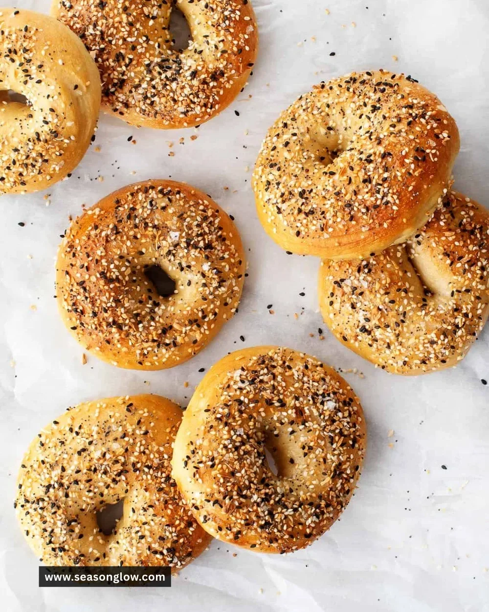 Freshly baked homemade bagels with sesame seeds on a wooden board