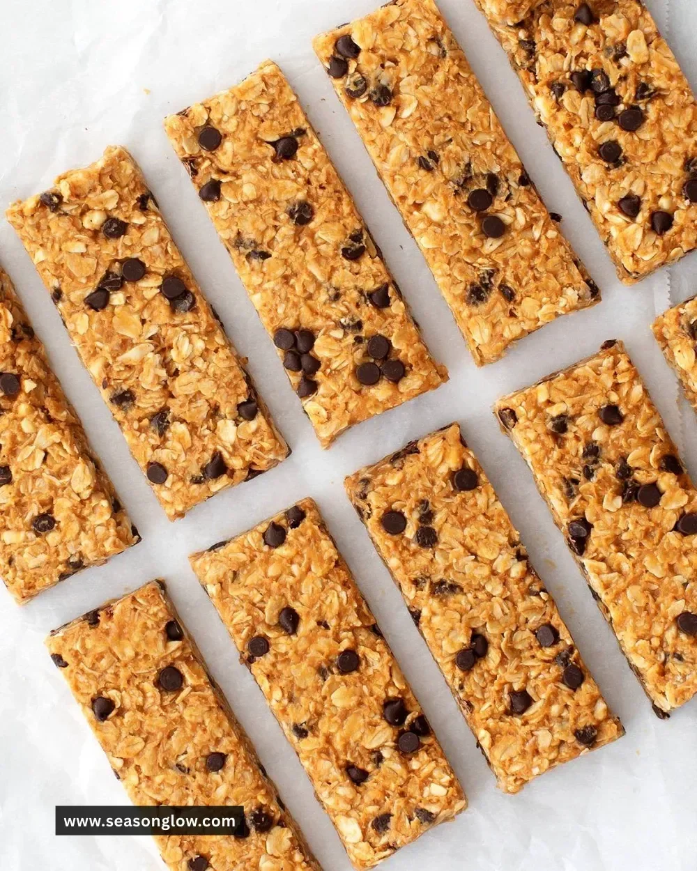 Homemade granola bars with oats, nuts, and dried fruits in a wooden bowl.