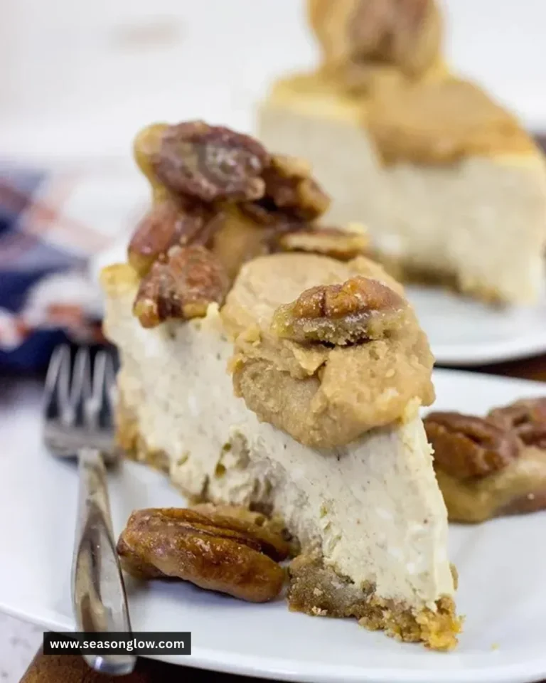 Delicious Maple Pecan Praline Cheesecake topped with pecans and drizzled in maple syrup.