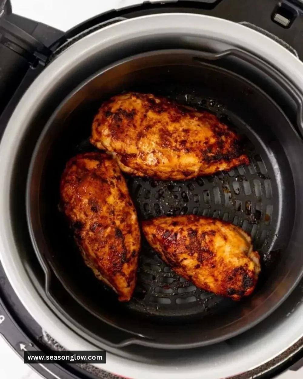 Cooked frozen chicken breast in a Ninja Foodi for quick meal preparation